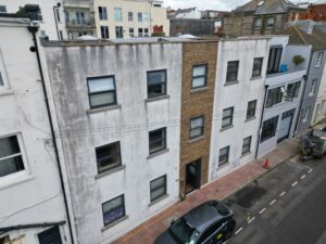 Exterior of a residential building in Brighton with visible render staining before cleaning