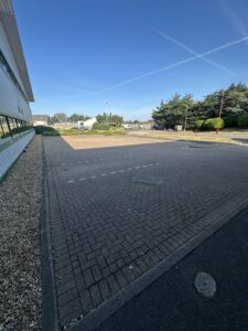 Block paving at a commercial site in Worthing before cleaning and pressure washing, with visible dark staining and dirt buildup